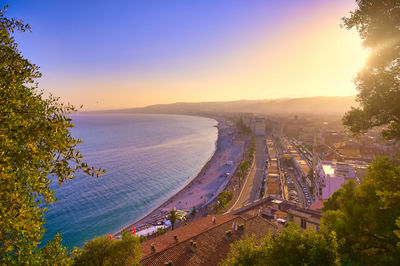 High angle view of river amidst city against sky at sunset