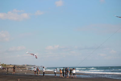 People on beach against sky