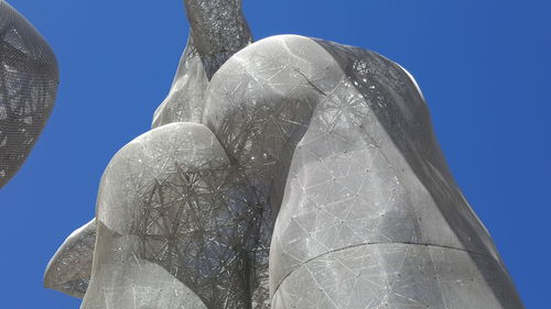 Low angle view of sculpture against clear blue sky