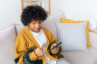 Portrait of young woman reading book at home