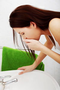 Woman washing face in sink