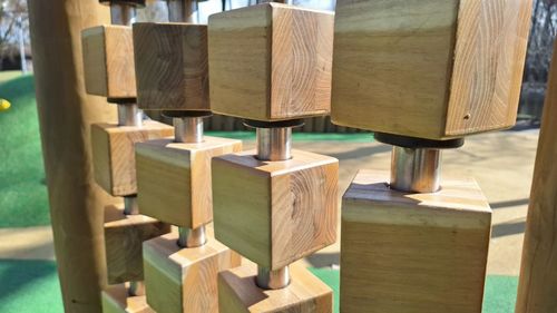 Wooden cubes and metal rods outdoor playground equipment close-up