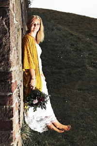 Portrait of smiling young woman standing against tree