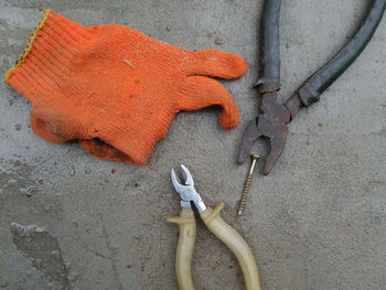 Glove with screw and hand tools on concrete