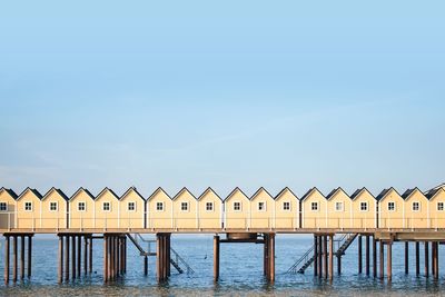 Beach huts by sea against sky