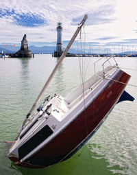 Sailboats moored on sea against sky