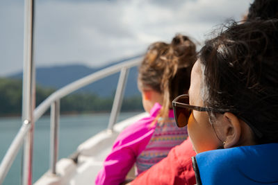 Little girl wearing sunglasses on a boat. view from behind. vacation, travel and active kid concept.