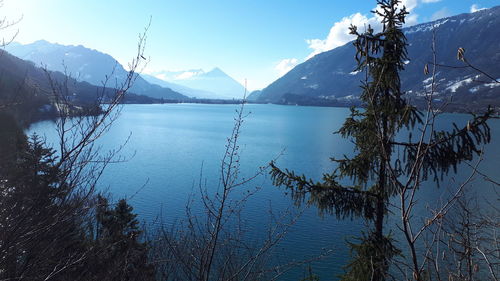 Scenic view of lake by snowcapped mountains against sky