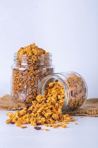 Close-up of jar on table against white background