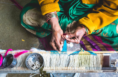 High angle view of woman working on loom in factory