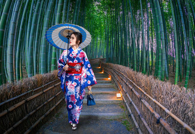 Full length of woman in kimono walking on footpath