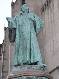 Low angle view of statue against old building