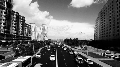 Traffic on road in city against sky