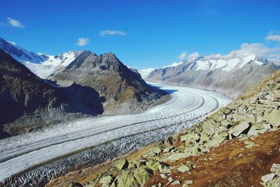 Scenic view of snowcapped mountains against blue sky