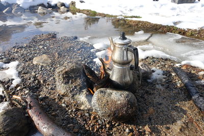 High angle view of kettle on burning fire during winter