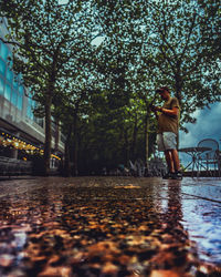 Woman standing by trees against plants