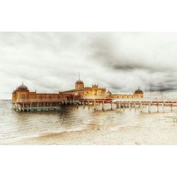 Pier on sea against cloudy sky