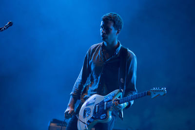 Man playing guitar at music concert