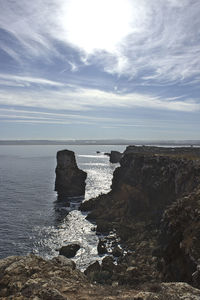 Rocks by sea against sky