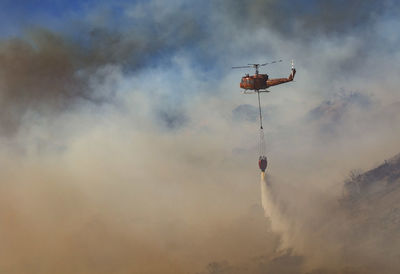 Low angle view of helicopter against sky