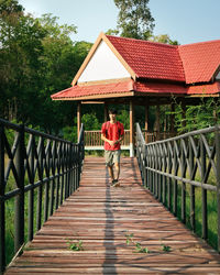 Rear view of man walking on footbridge