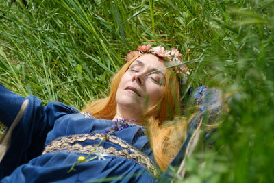 Portrait of young woman relaxing on field