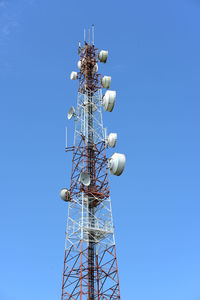 Low angle view of communications tower against blue sky