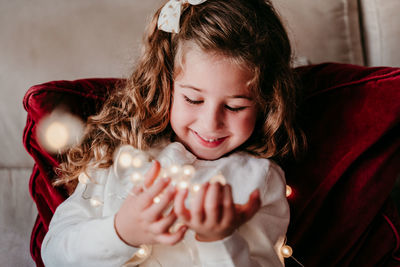 Portrait of smiling girl holding indoors at home