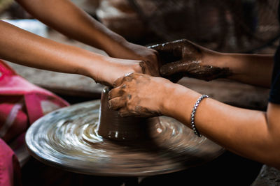 Cropped hands making clay pot