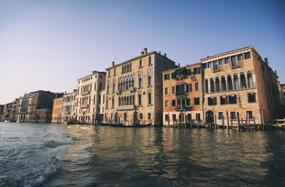 View of buildings by sea against clear sky