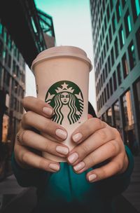 Midsection of woman holding coffee cup