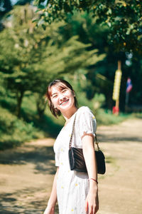 Portrait of young woman standing on field