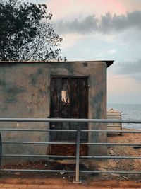 Exterior of old building by sea against sky