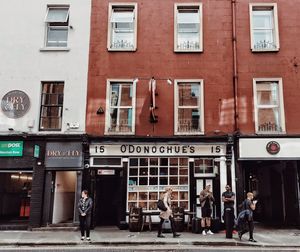 People walking on street against building in city