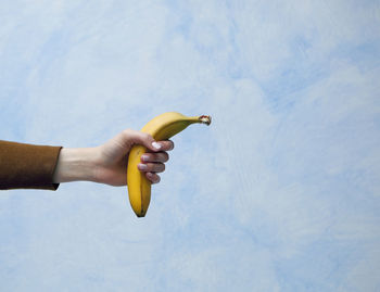 Midsection of person holding banana
