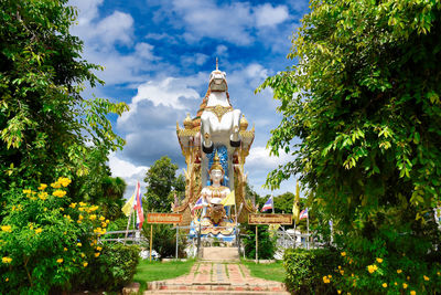 Statue amidst trees against sky