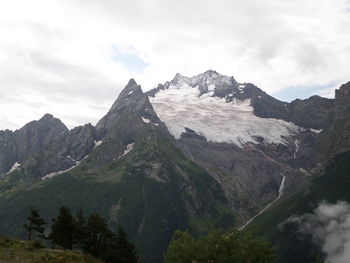 Scenic view of mountains against cloudy sky