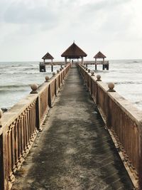View of pier on beach against sky