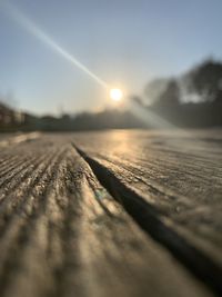 Surface level of wood against sky during sunset