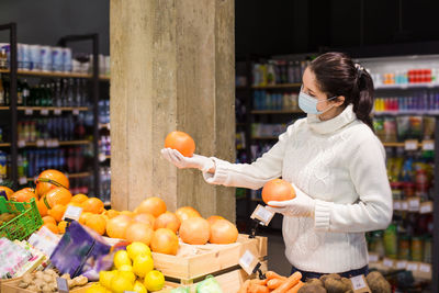 Woman standing by fruits