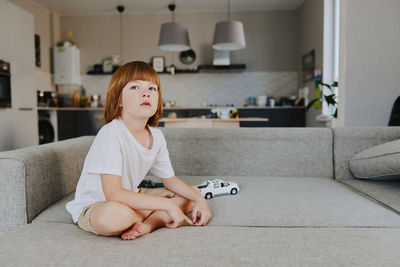 Portrait of young woman sitting on sofa at home