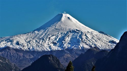 Scenic view of snowcapped mountains against clear blue sky