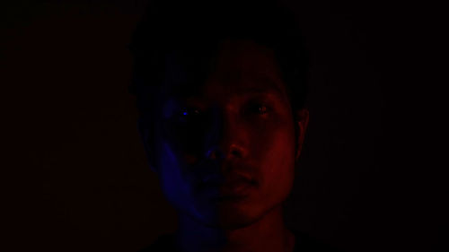 Portrait of man against black background