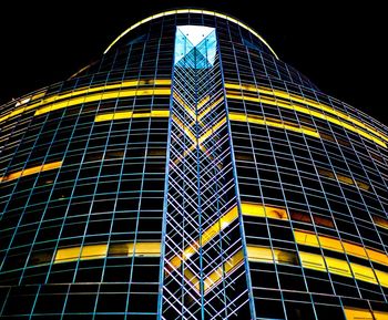 Low angle view of illuminated skyscraper against sky at night