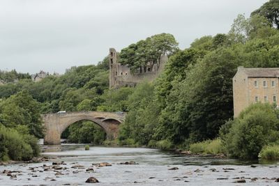 Arch bridge over river against sky