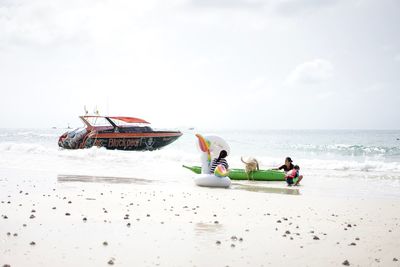 People on beach against sky