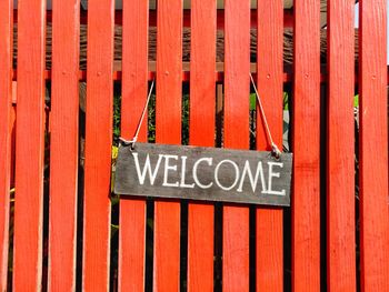 Close-up of welcome sign on wooden fence