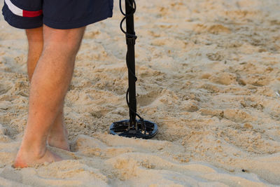 Man on the beach with metal detector