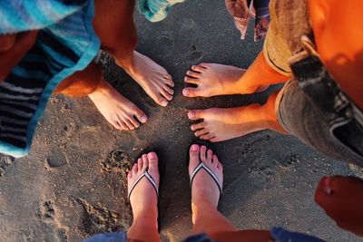 Low section of friends standing at beach