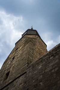 Low angle view of old tower in dinan against sky